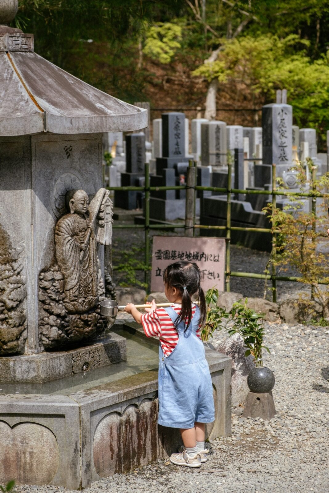 A young girl in a kimono performs a ritual at a Japanese shrine