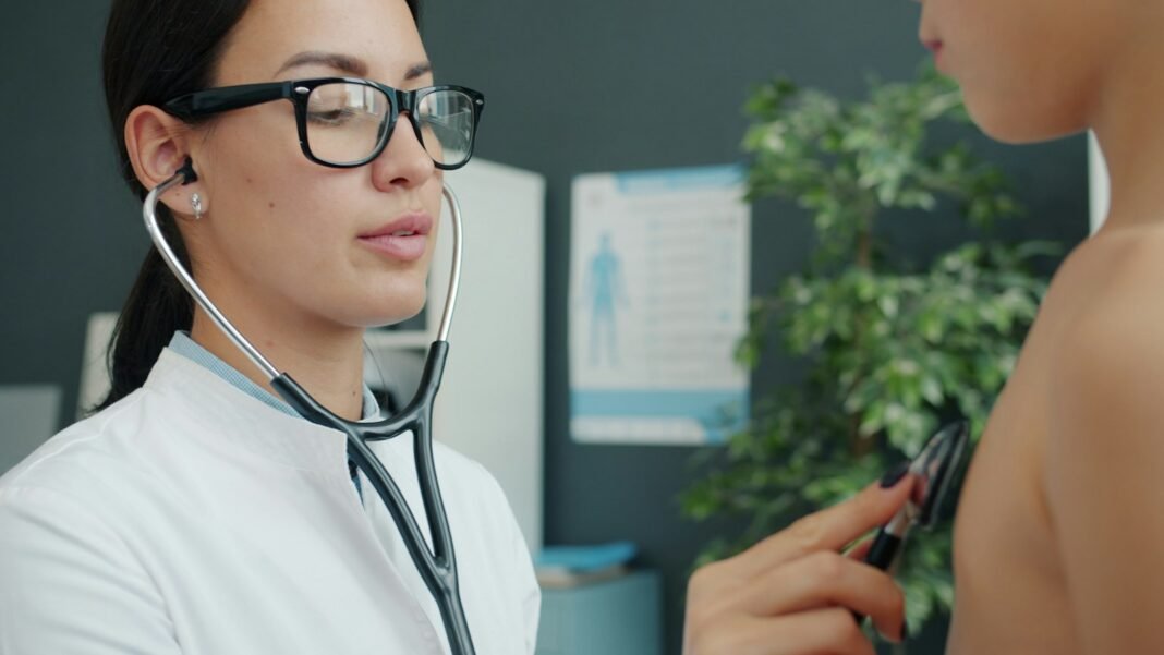 A pediatrician examines a young child with a stethoscope in a clinic