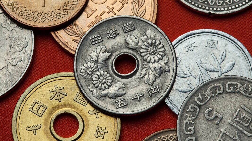 Japanese yen coins, including 5-yen and 50-yen coins, on a red background